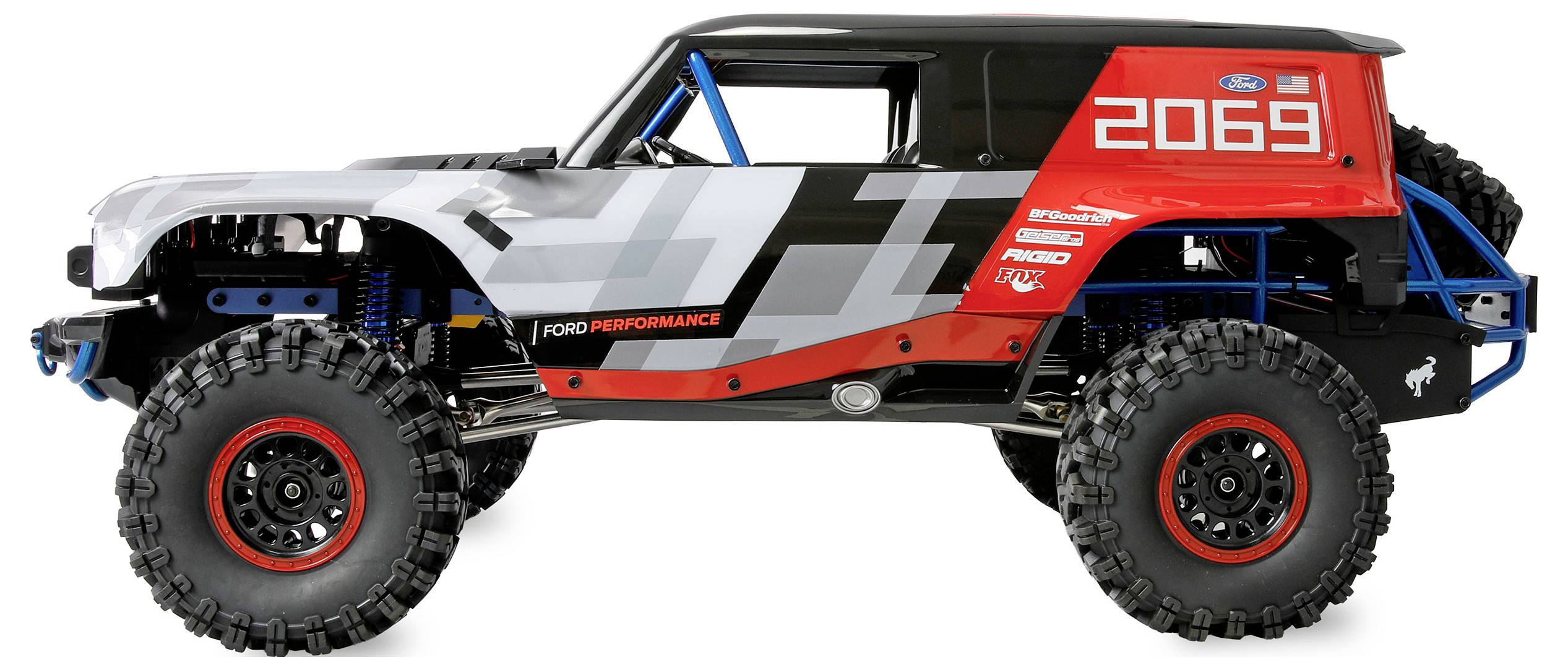 Zijkant van een Ford performance terrein-/rotsklimmer met overmaatse banden, zwart-grijs-rood design, en racenummer 2069 op een witte achtergrond.