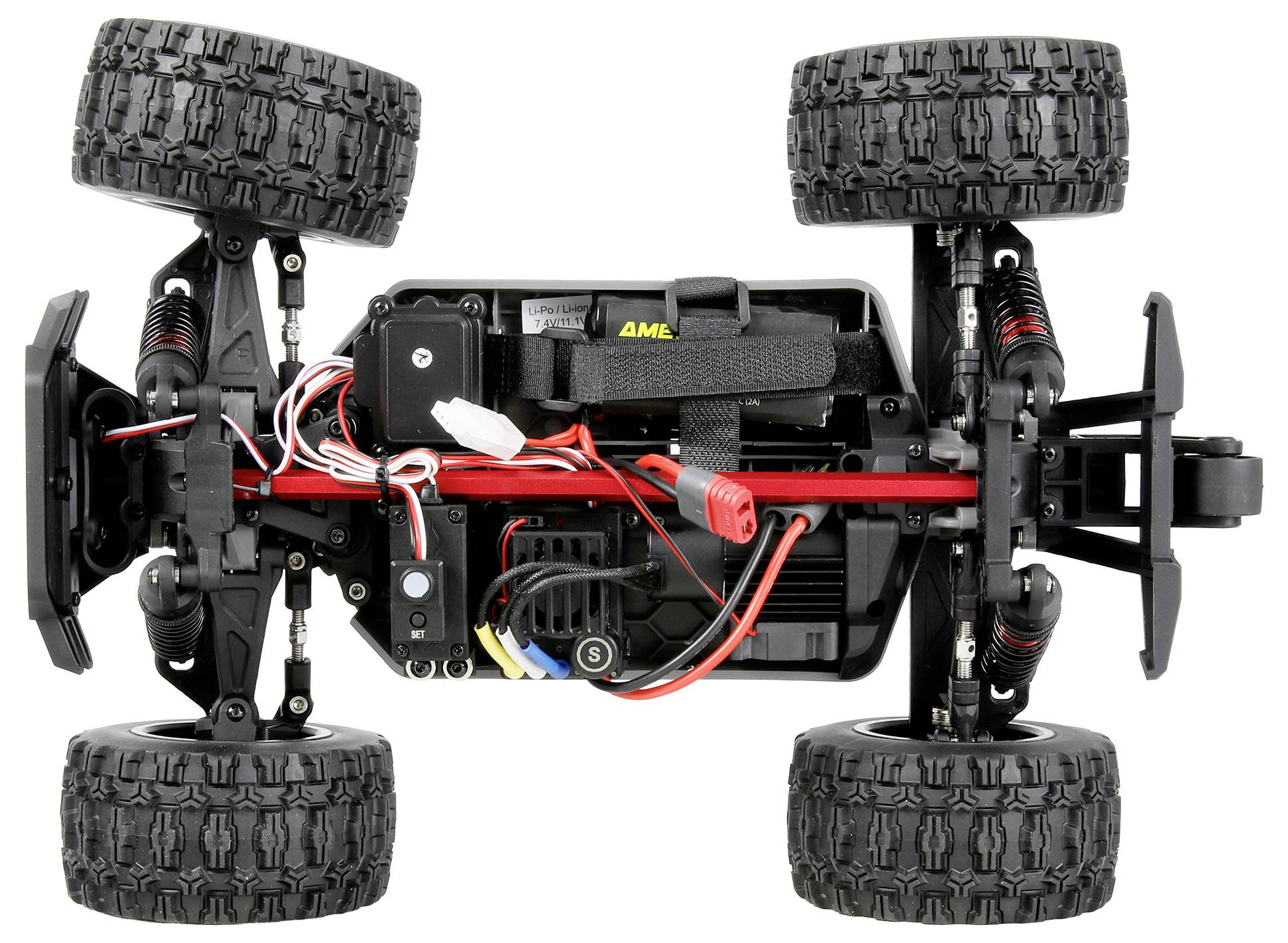Onderaanzicht van een off-road RC-autochassis met vier grote noppen-banden, ophanging, motor, batterij en bedrading op een witte achtergrond.