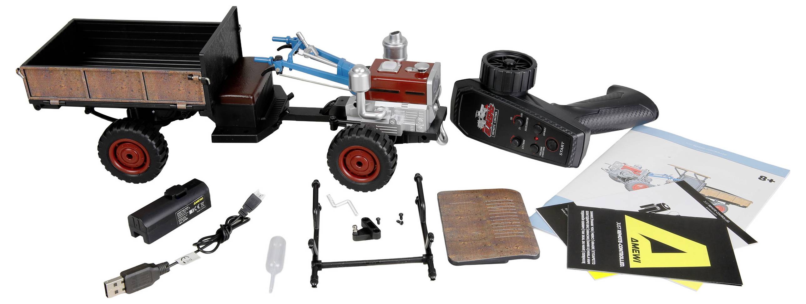 Speelgoed afstandsbediende tractor met aanhanger, getoond met controller, oplader, batterij en instructiebladen uitgelegd op een witte achtergrond.