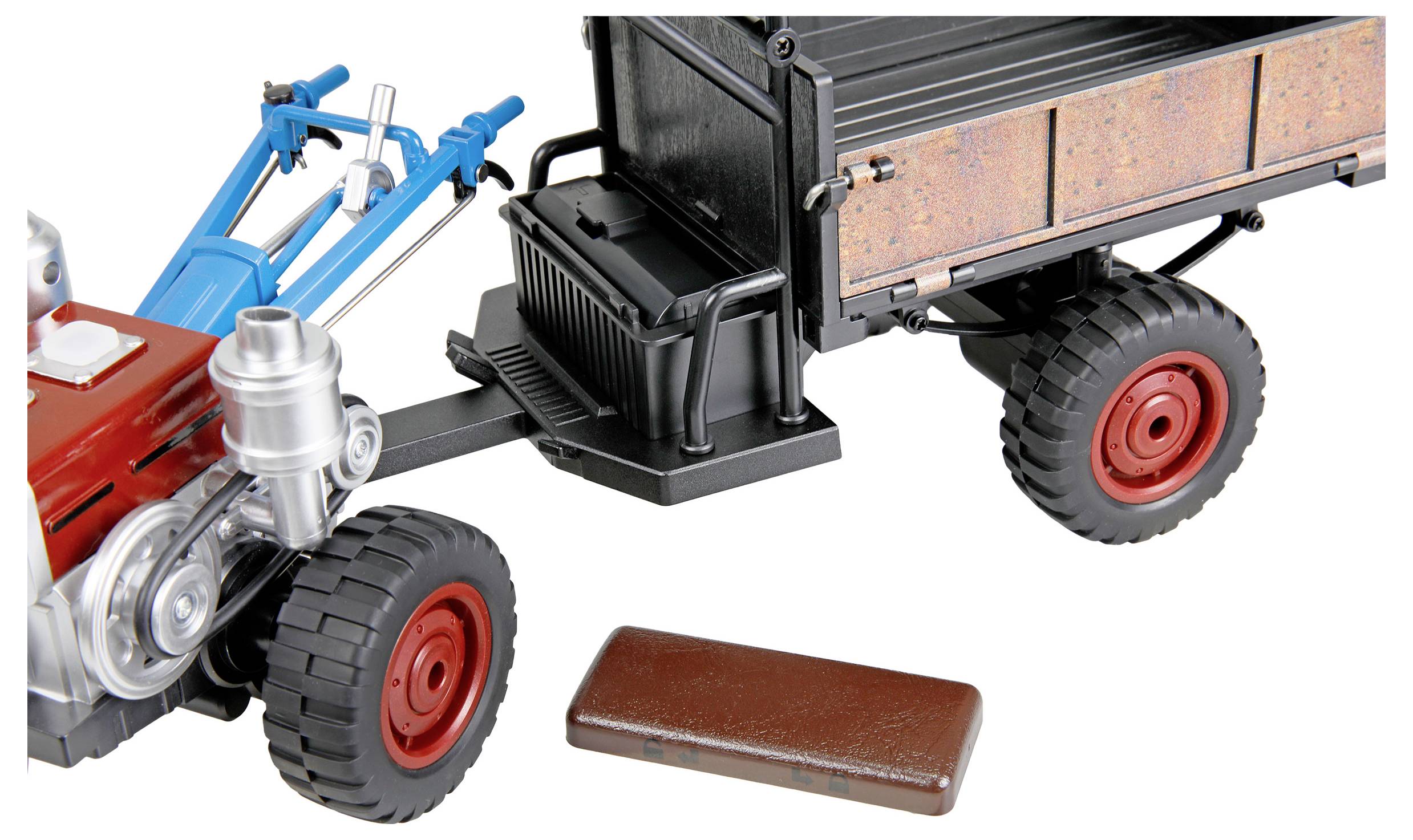 Speelgoed tractor cabine en aanhanger met rode wielen, afzonderlijk weergegeven van een bruin vrachtonderdeel op een witte achtergrond.
