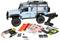 Blauwe RC terreinwagen met afstandsbediening en reserve decals, onderdelen, gereedschap, batterij en oplaadkabel uitgespreid op een witte achtergrond.
