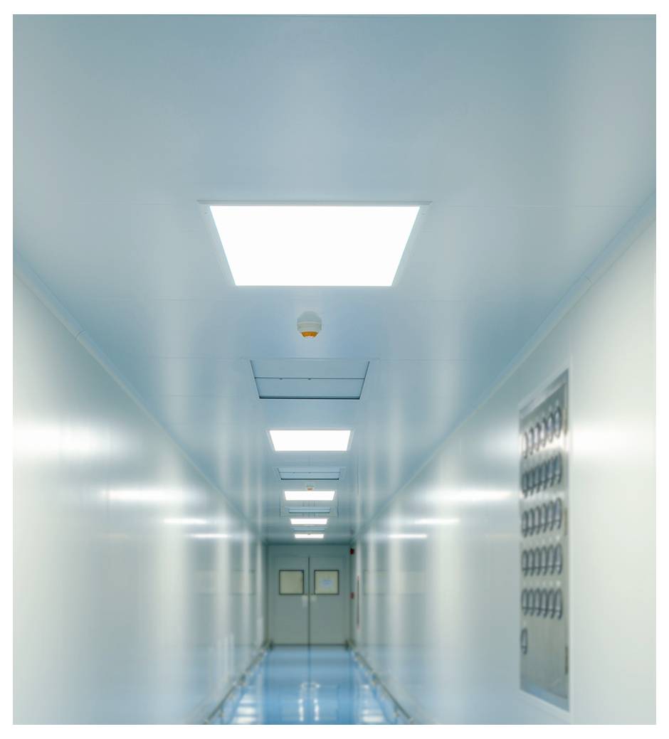 Een witte rechthoekige aan de muur bevestigde lichtfixture met een lang doorschijnend LED-paneel bovenop.