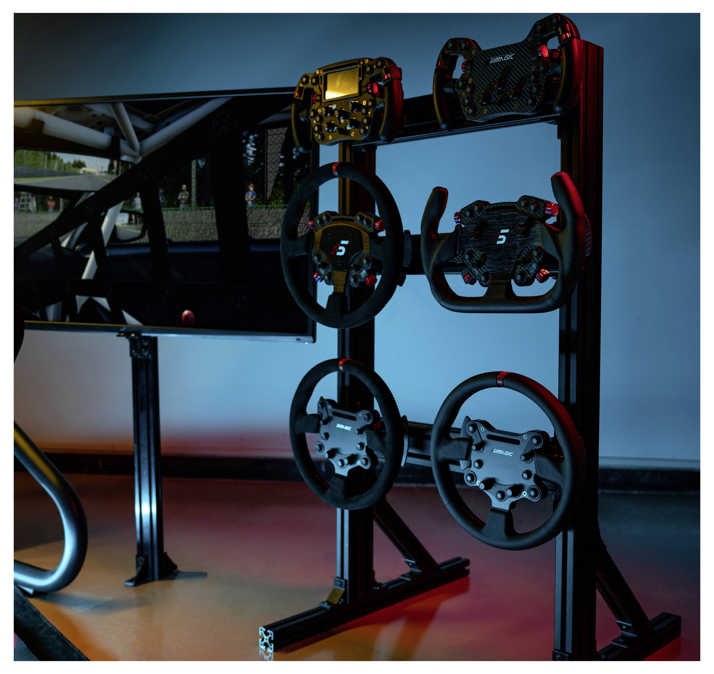 Racingsimulator-display met meerdere stuurwielen op een standaard naast een monitor, verlicht door blauwe en rode accentverlichting.