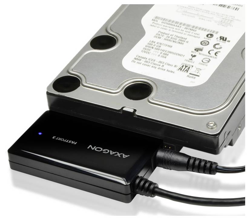 Externe harde-schijfadapter aangesloten op een desktopharde-schijfstation met twee USB-kabels eraan bevestigd.