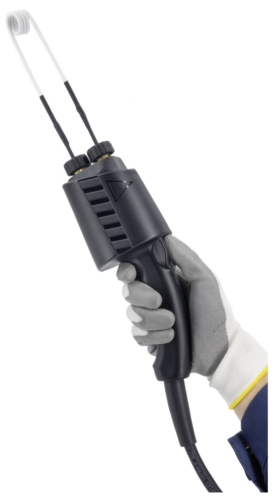 Gehandschoende hand die een handheld elektrisch gereedschap met twee metalen punten vasthoudt, waarschijnlijk een las- of verwarmingsapparaat, tegen een witte achtergrond.