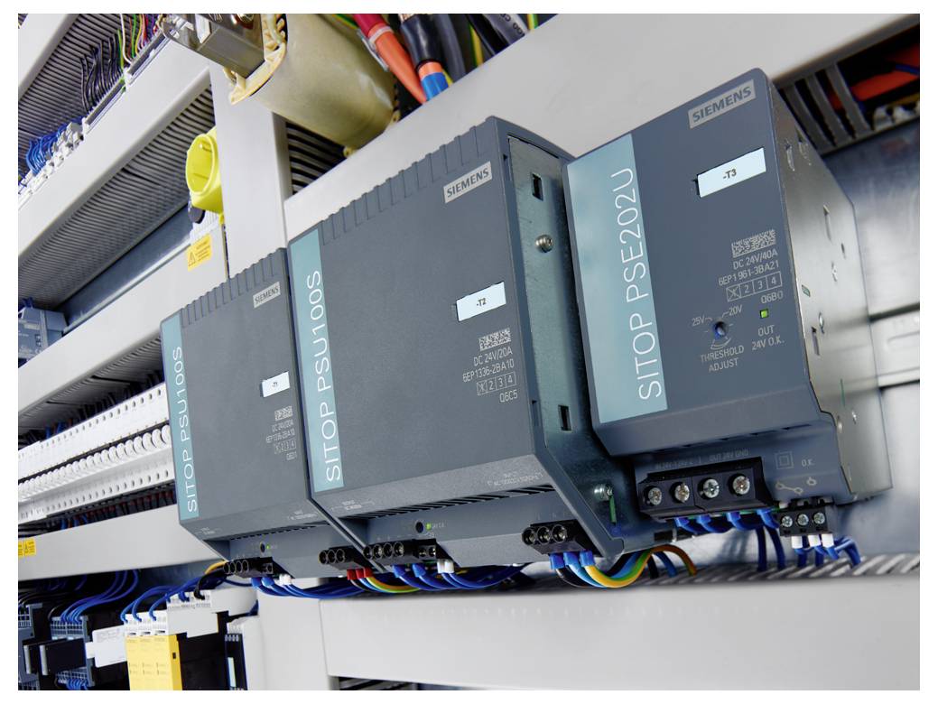 Drie Siemens SITOP PSU100S en PSU6200 voedingseenheden gemonteerd in een elektrische controlekast met bedrading en aansluitklemmen.