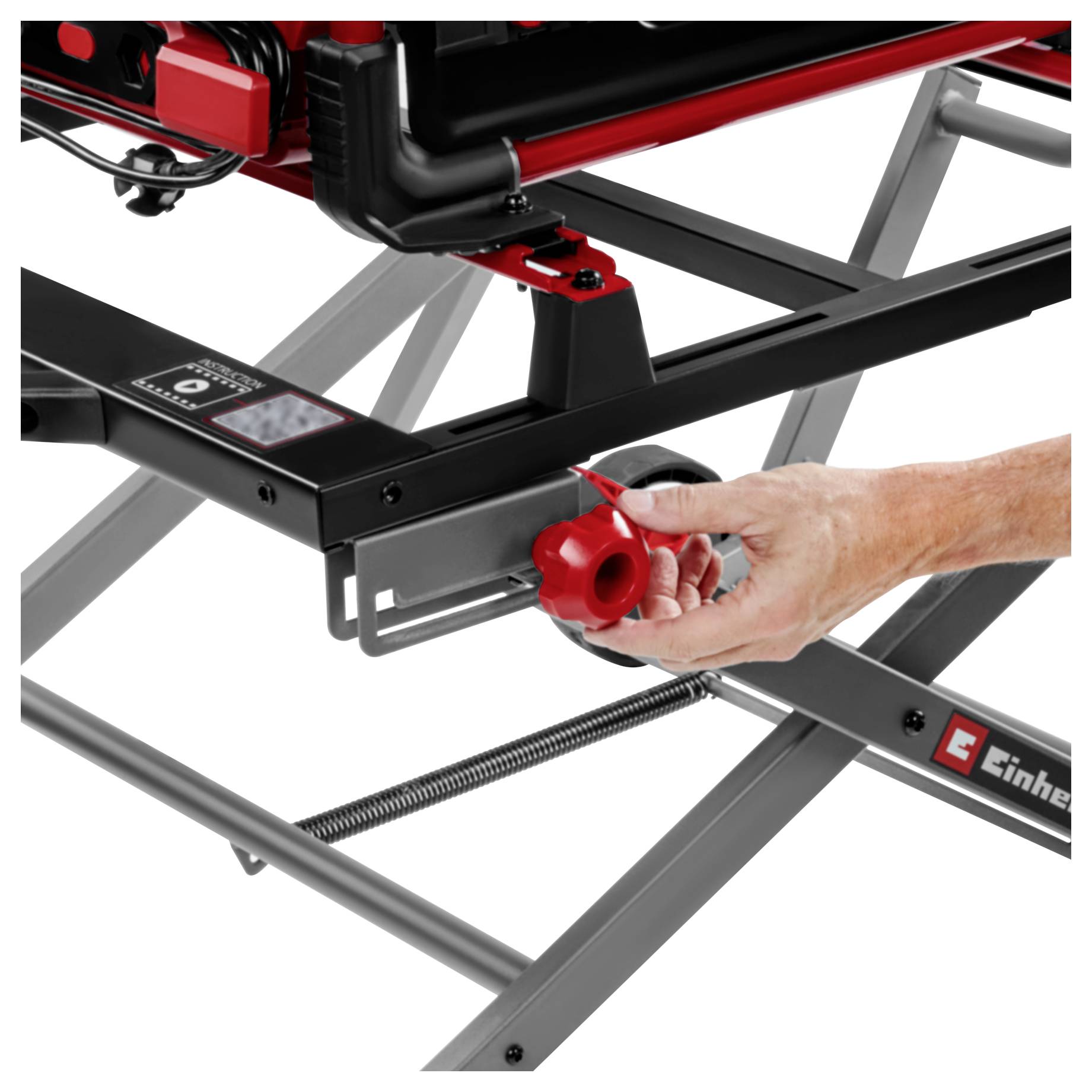 Hand stelt een rode knop af op een zwart metalen schaartafel of standaard.