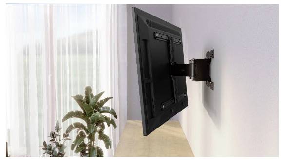 Flatscreen-tv aan een muur bevestigd met een uitschuifbare zwenkelbeugel, gezien van opzij boven een houten oppervlak in de buurt van een raam en planten.