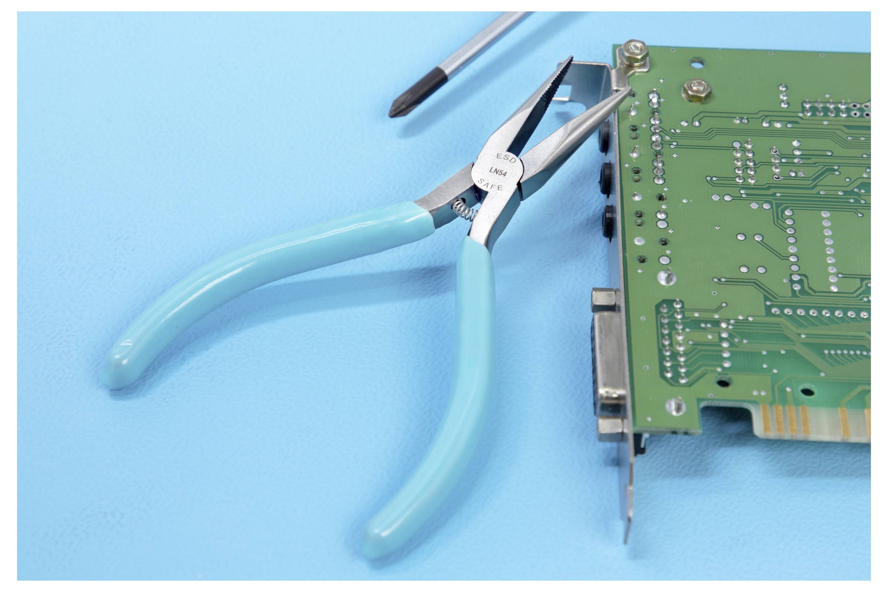 Blauwe tang en een schroevendraaier naast een groen printplaatje op een blauw oppervlak, wat wijst op reparatie of montage van elektronische apparatuur.