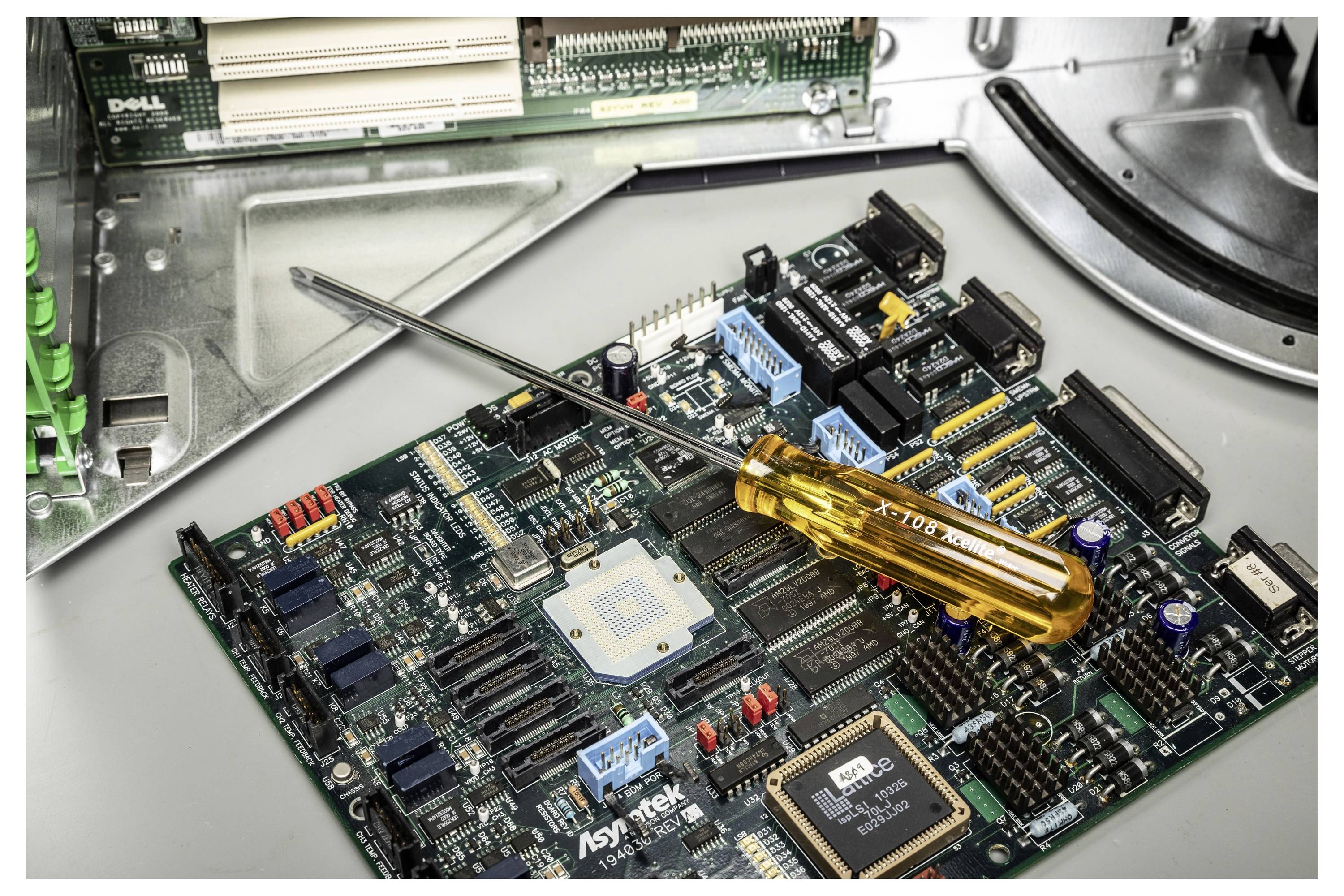 Een schroevendraaier rust op een computermoederboard in een open Dell-systeem, waarbij interne hardware wordt onderhouden.