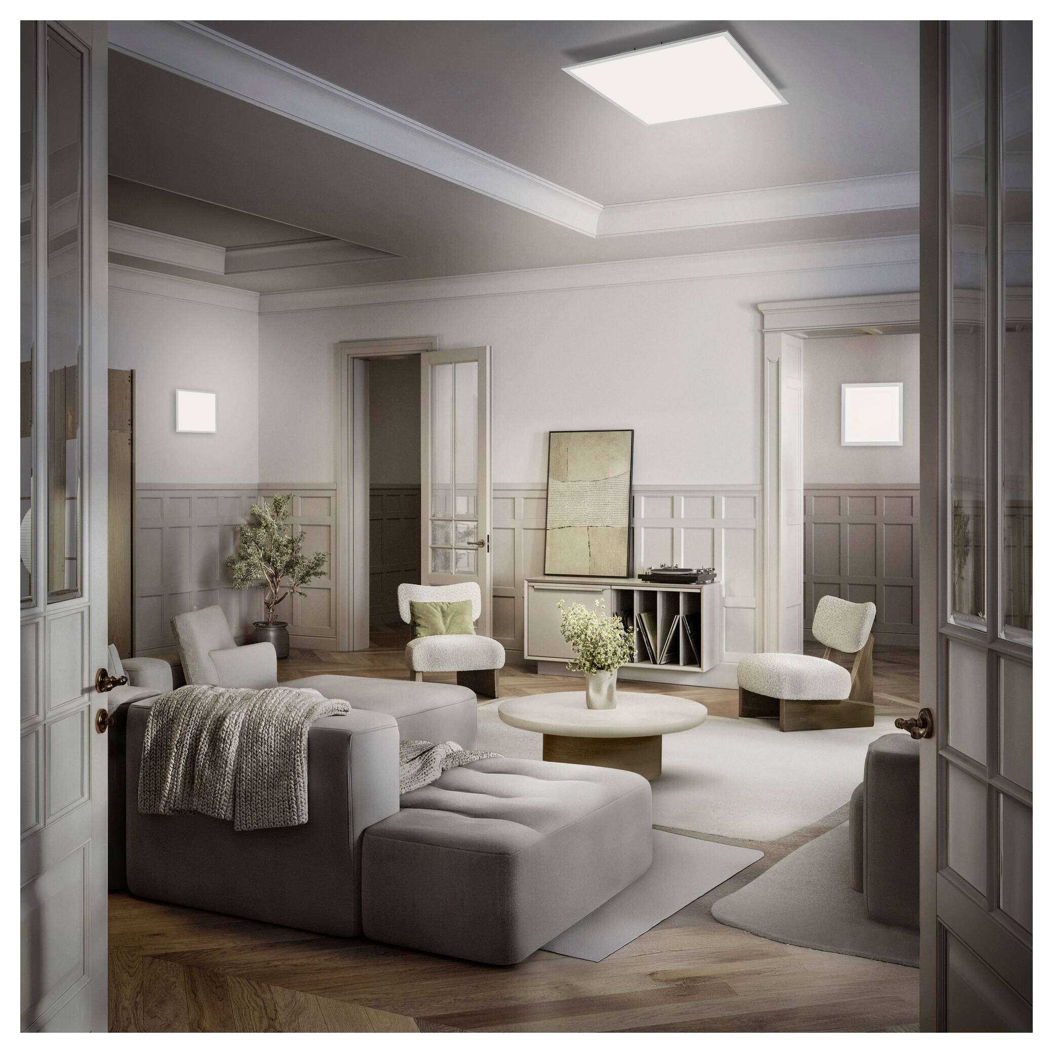 Elegante woonkamer met neutrale zitplaatsen, rond koffietafel, kunstwerk en daklicht, gezien door open dubbele deuren.
