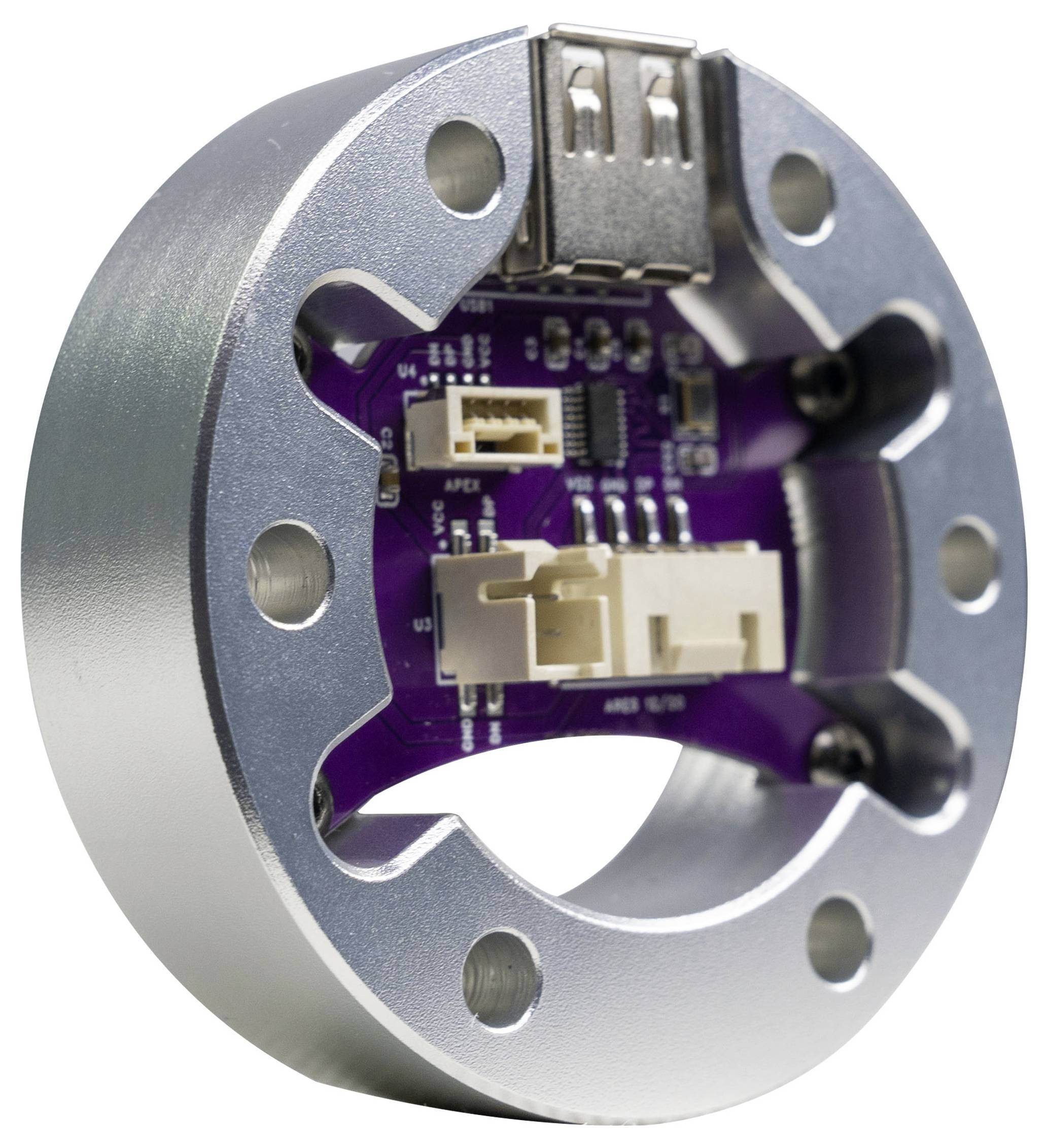 Close-up van een ronde metalen behuizing van een elektronisch apparaat met een paars printplaatje en connectoren erin, weergegeven tegen een witte achtergrond.