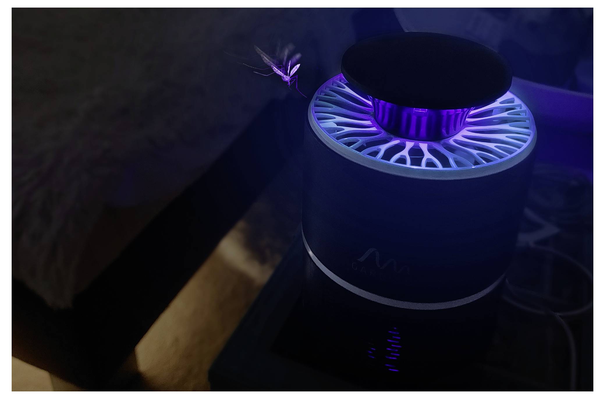 Een gloeiiend paars-blauw cilindrisch apparaat met een rond bovenkant staat op een oppervlak naast een bed in een halfdonkere kamer, met een klein lichtje erboven.