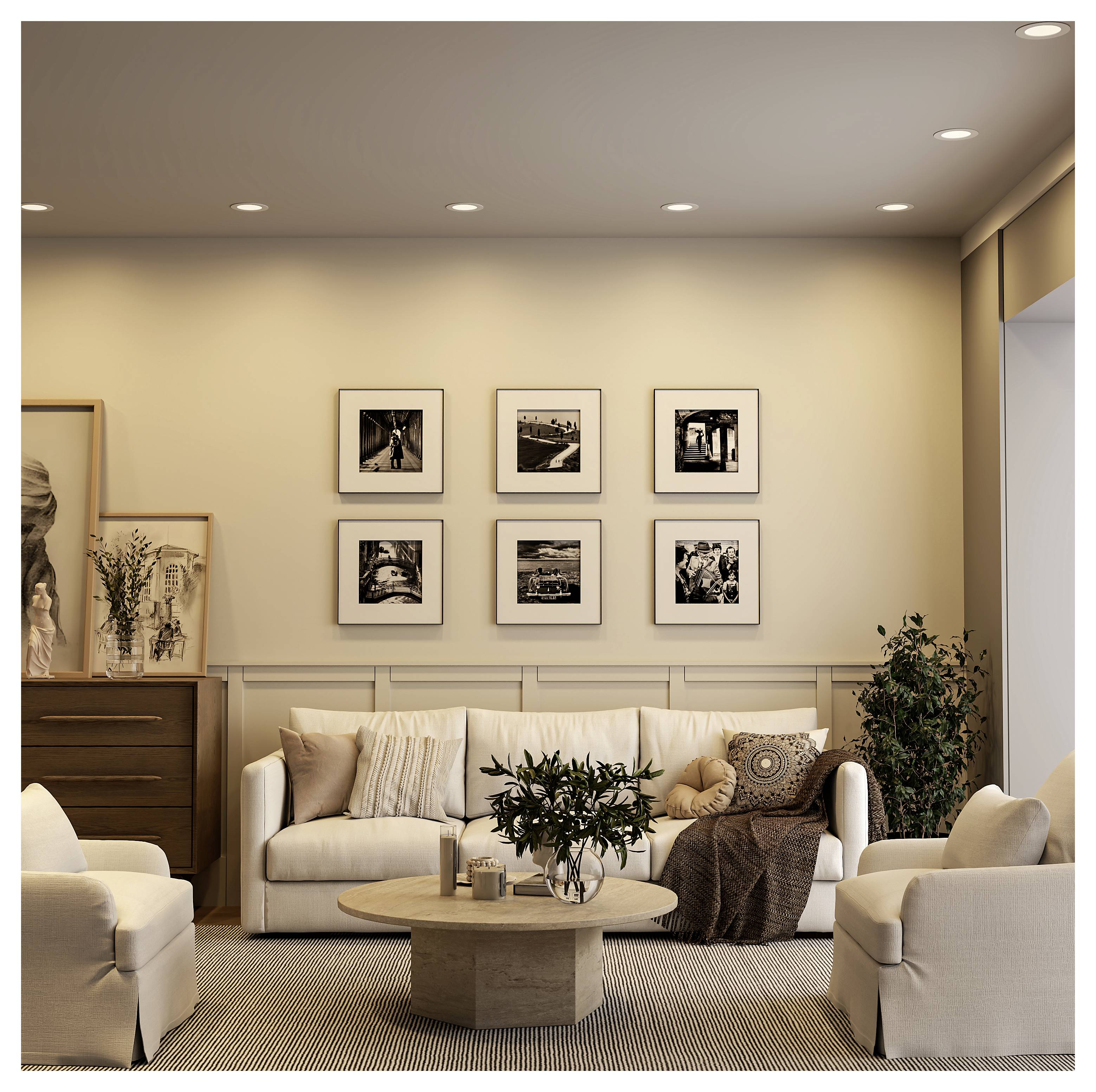 Een gezellige moderne woonkamer met een crèmekleurige bank, fauteuils, ronde salontafel, ingelijste wandkunst en warm ingebouwde verlichting.