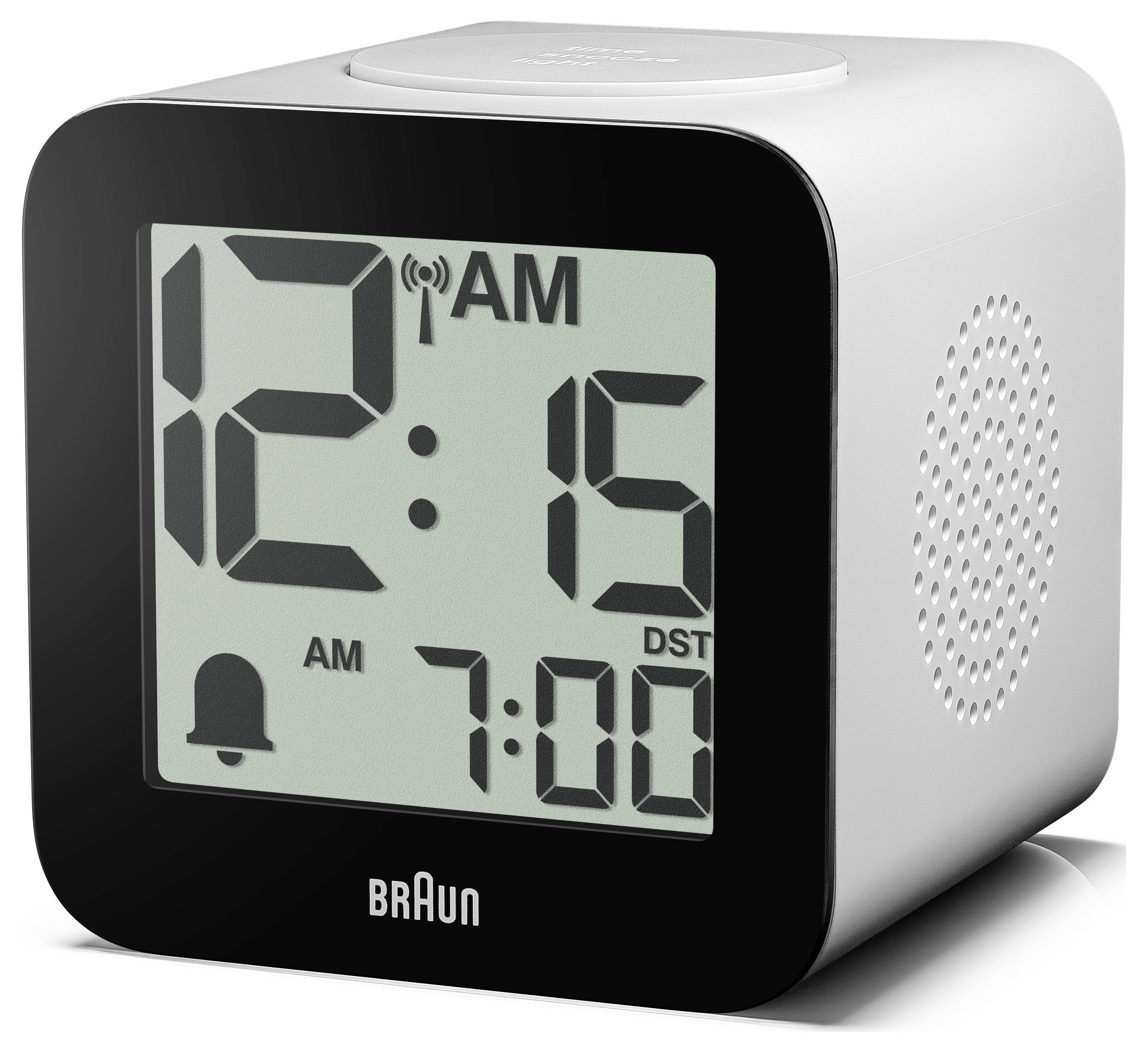 Digitale Braun wekker met display dat 12:15 AM toont en alarmingestelling op 7:00, met AM en DST indicatoren en luidsprekergril aan de zijkant.