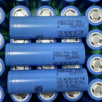 Drie blauwe cilindrische lithium-ionbatterijen gestapeld in een lade, gelabeld 'INR21700-50G 4900mAh', met een brandgevaarwaarschuwing.