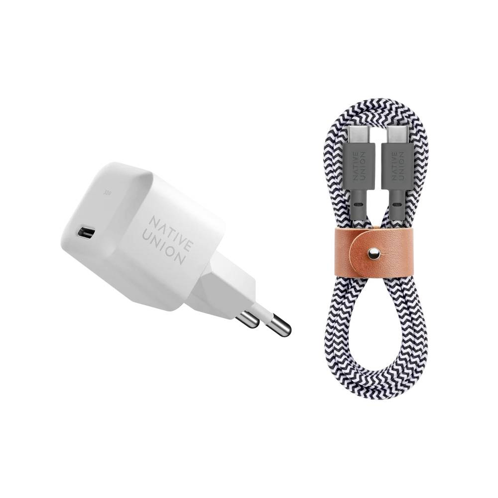 Witte Native Union USB-wandlader naast een opgerolde gevlochten oplaadkabel die met een lederen riem is beveiligd.