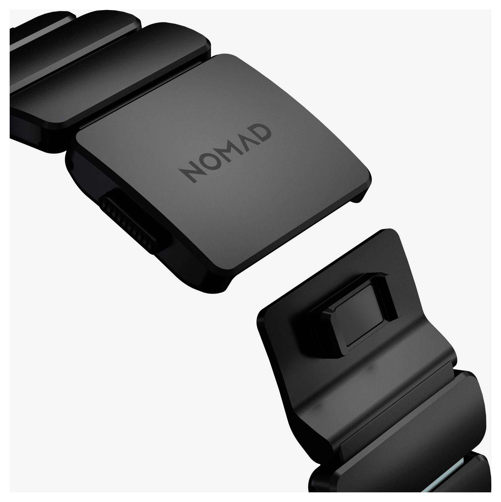 Zwart NOMAD horlogebandje met twee magnetische sluitstukken weergegeven gescheiden op een witte achtergrond.