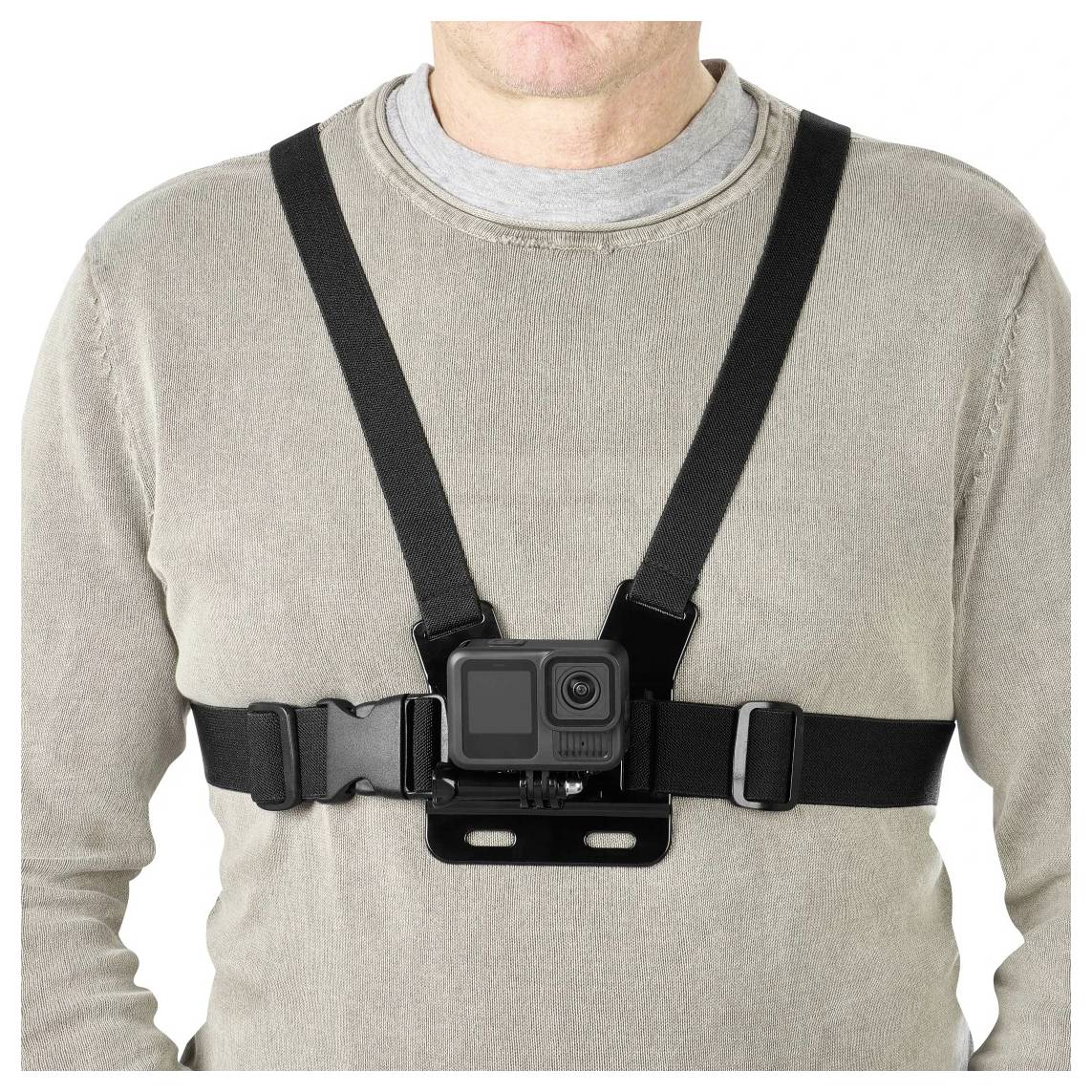 Persoon die een op de borst gemonteerde actioncameraharnas draagt over een grijs shirt op een effen witte achtergrond.
