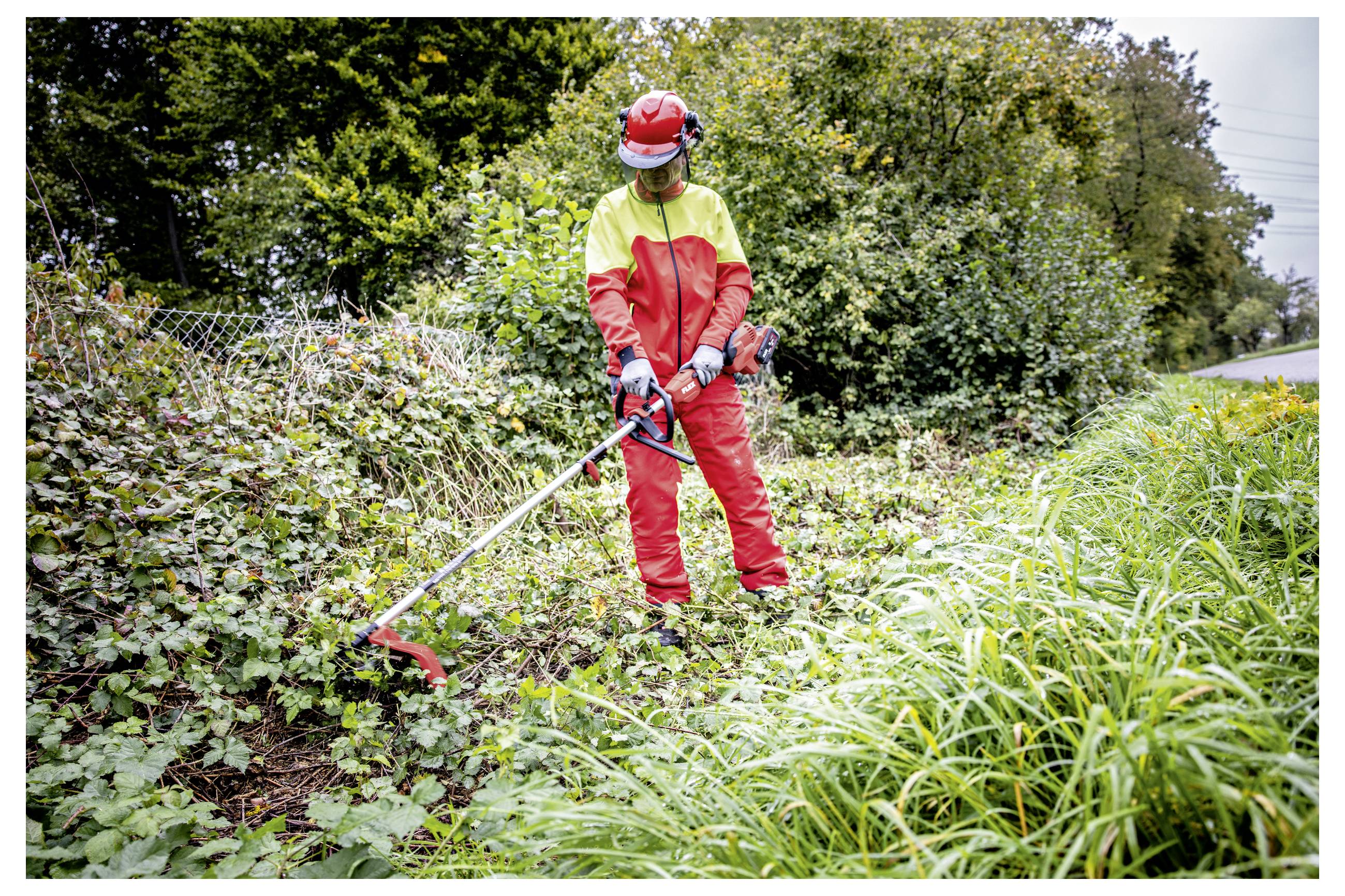 Werknemer in rood en geel veiligheidsmateriaal gebruikt een stringtrimmer om overwoekerde begroeiing langs een weg of pad op te ruimen.