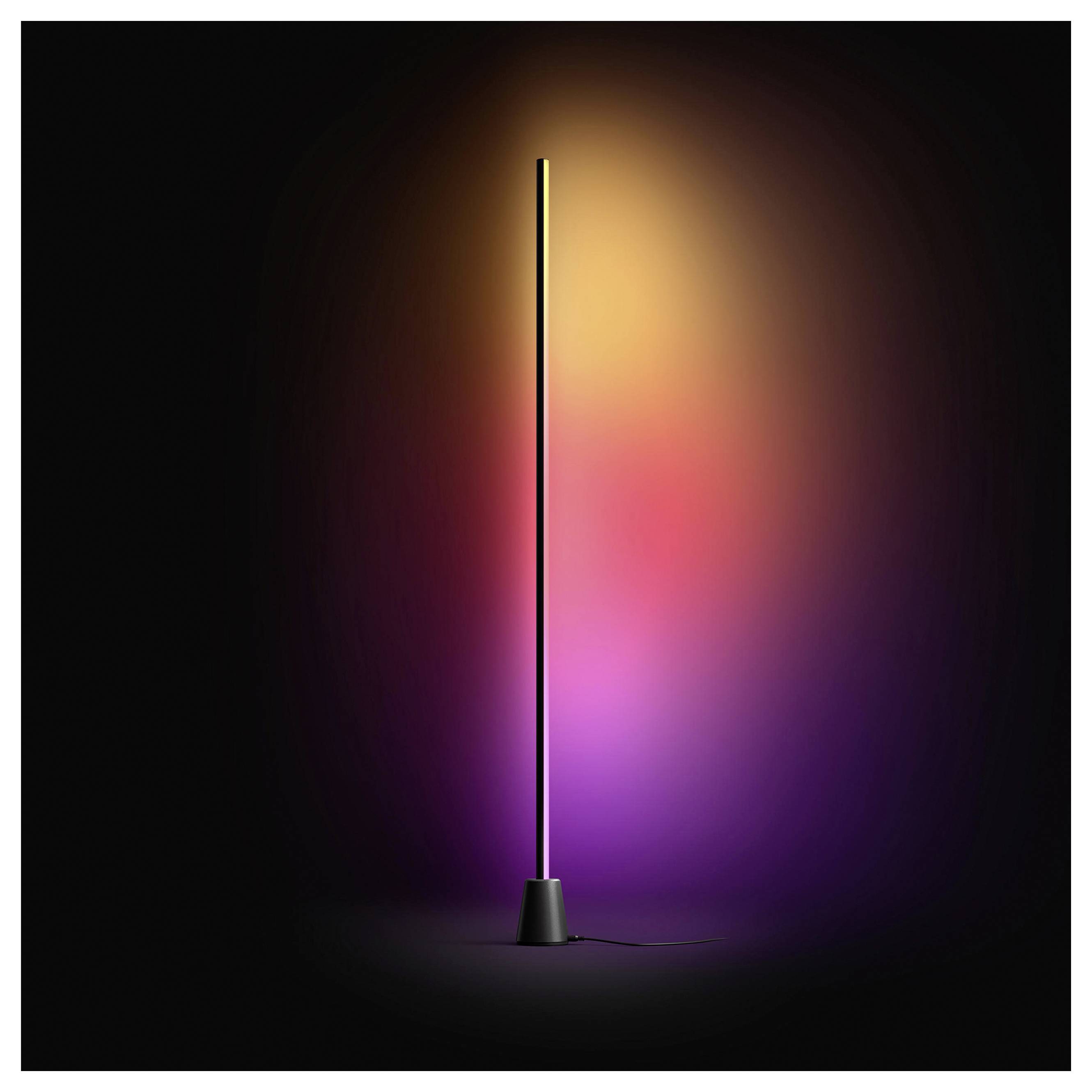 Een slank zwart staande lamp met een gloeiende verticale LED-strip, die een warme oranje, roze en paarse gradiënt tegen een donkere achtergrond werpt.