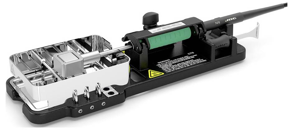 Mechanisch apparaat met een zwarte basis, zichtbare metalen onderdelen, groene cilinder en een uitstekende staaf, weergegeven in zijaanzicht op een witte achtergrond.