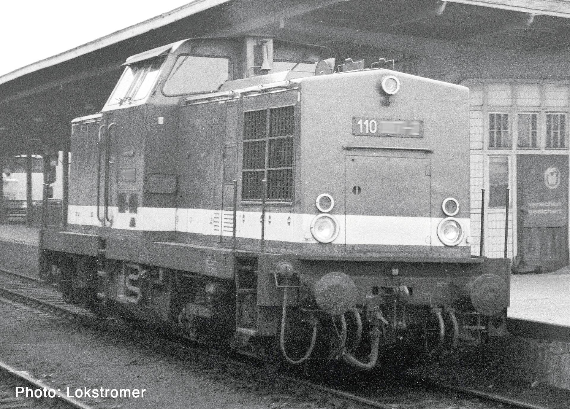 Een diesellocomotief met nummer 110 staat op een stationperron in zwart-wit, gezien vanaf de voorkant-linkerkant.