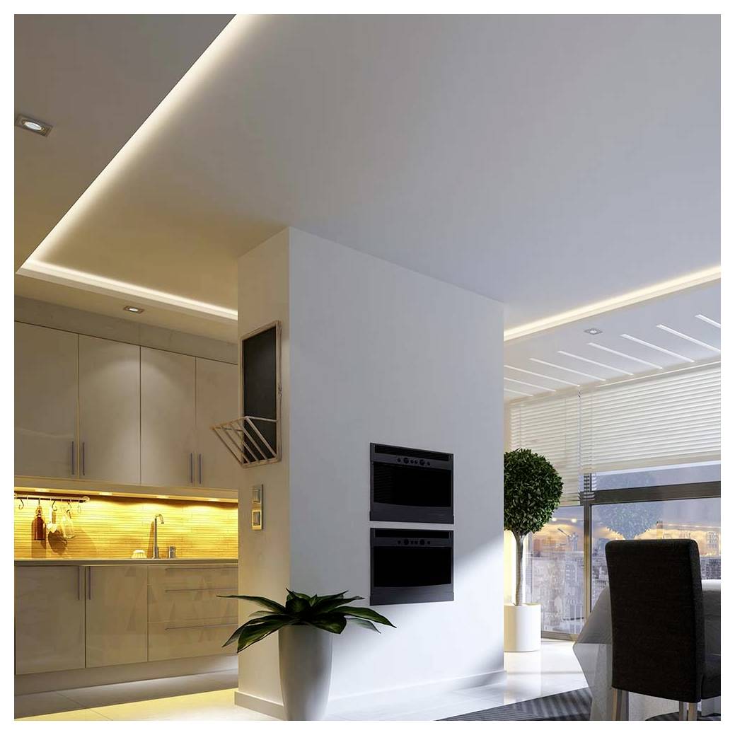 Modern openplan appartement met strakke keuken, centraal wit zuiltje met ingebouwde ovens, en eethoek bij grote ramen met uitzicht op de stad.