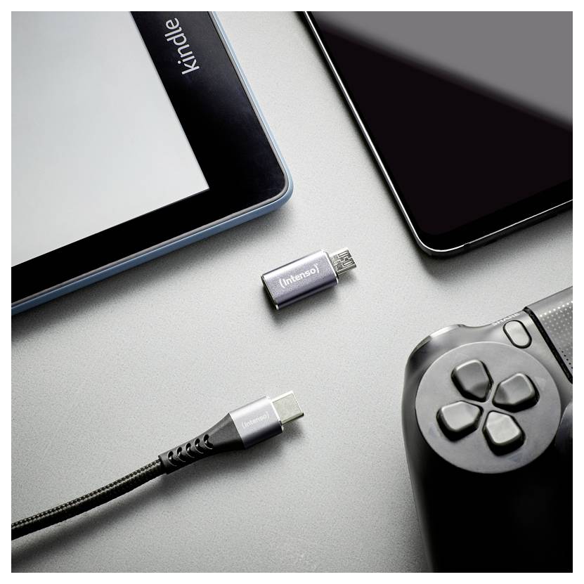 Verschillende apparaten en connectoren op een grijs oppervlak: tablet, smartphone, game controller, USB-C-kabel en twee kleine adapterpluggen.