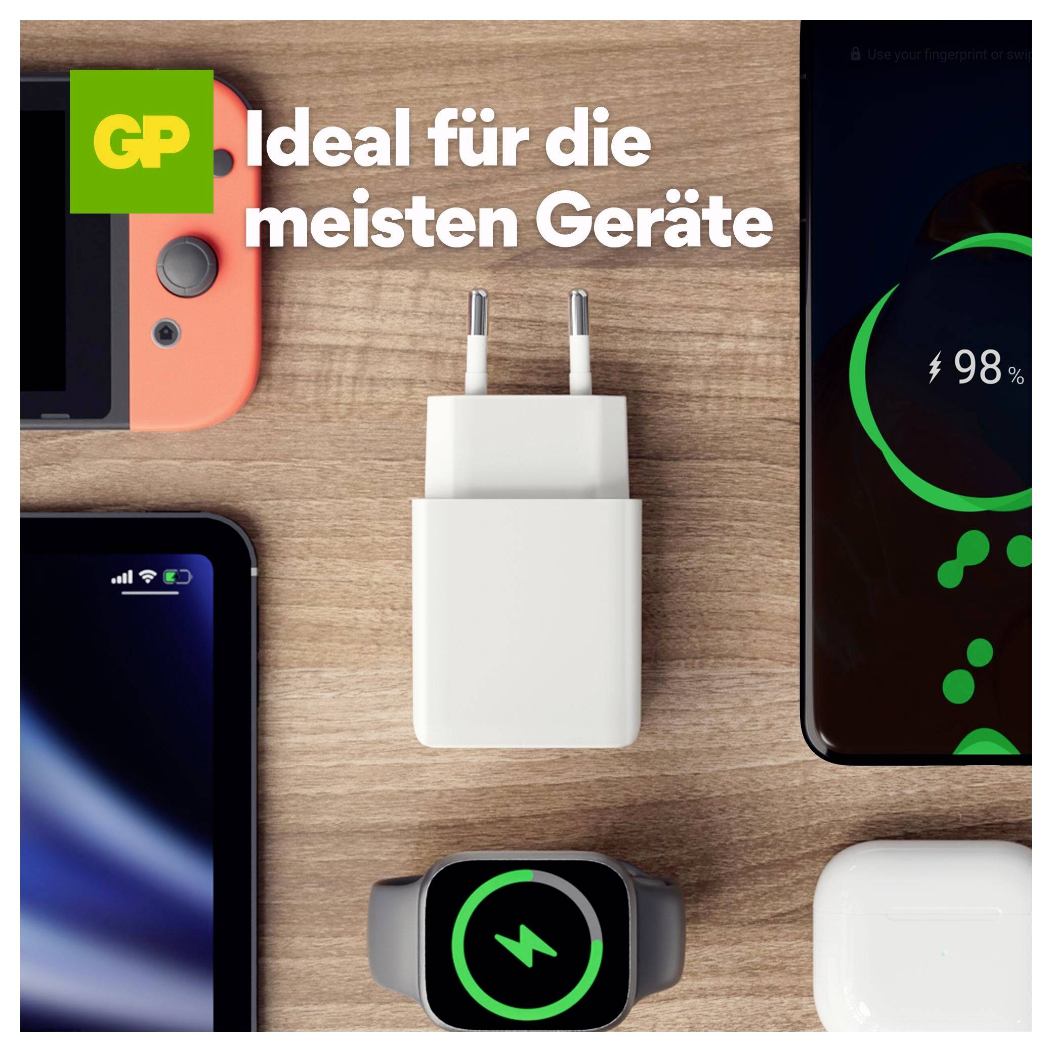 Advertentie met een witte twee-pins stroomadapter op een houten oppervlak met telefoons en een smartwatch; de Duitse tekst luidt 'Ideaal voor de meeste apparaten'.