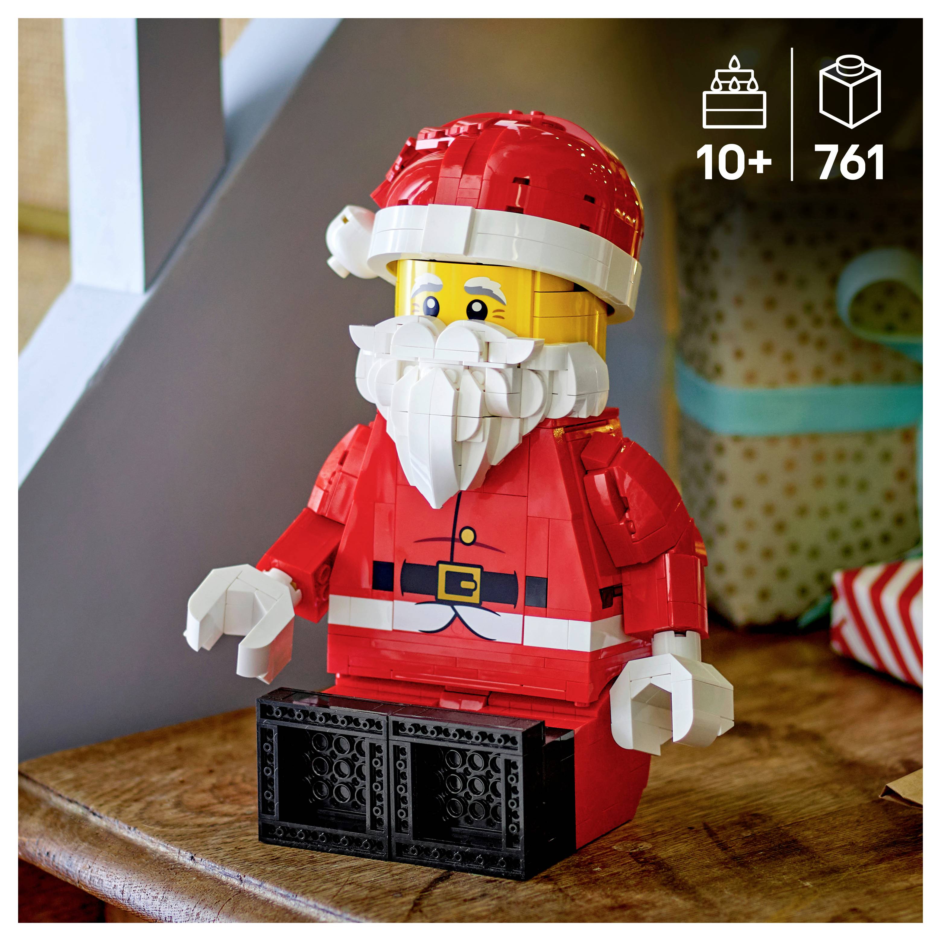 LEGO Kerstman-model in rood pak en hoed, met witte baard, zittend op een houten oppervlak; pictogram toont 10+ en 761 stukken.
