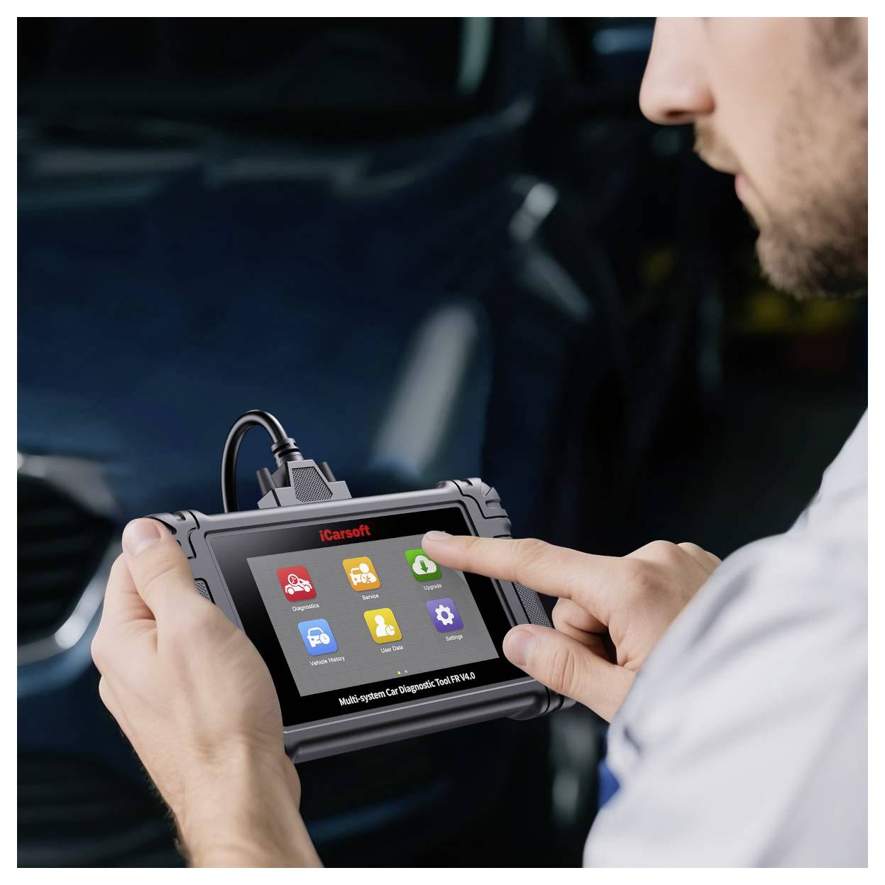 Monteur die een handheld iCarsoft auto-diagnoscanner gebruikt, tikend op het touchscreen in een voertuigreparatieomgeving.