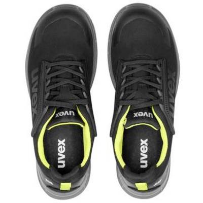 Bovenaanzicht van een paar zwarte Uvex sportschoenen met neongeelaccenten op een witte achtergrond.