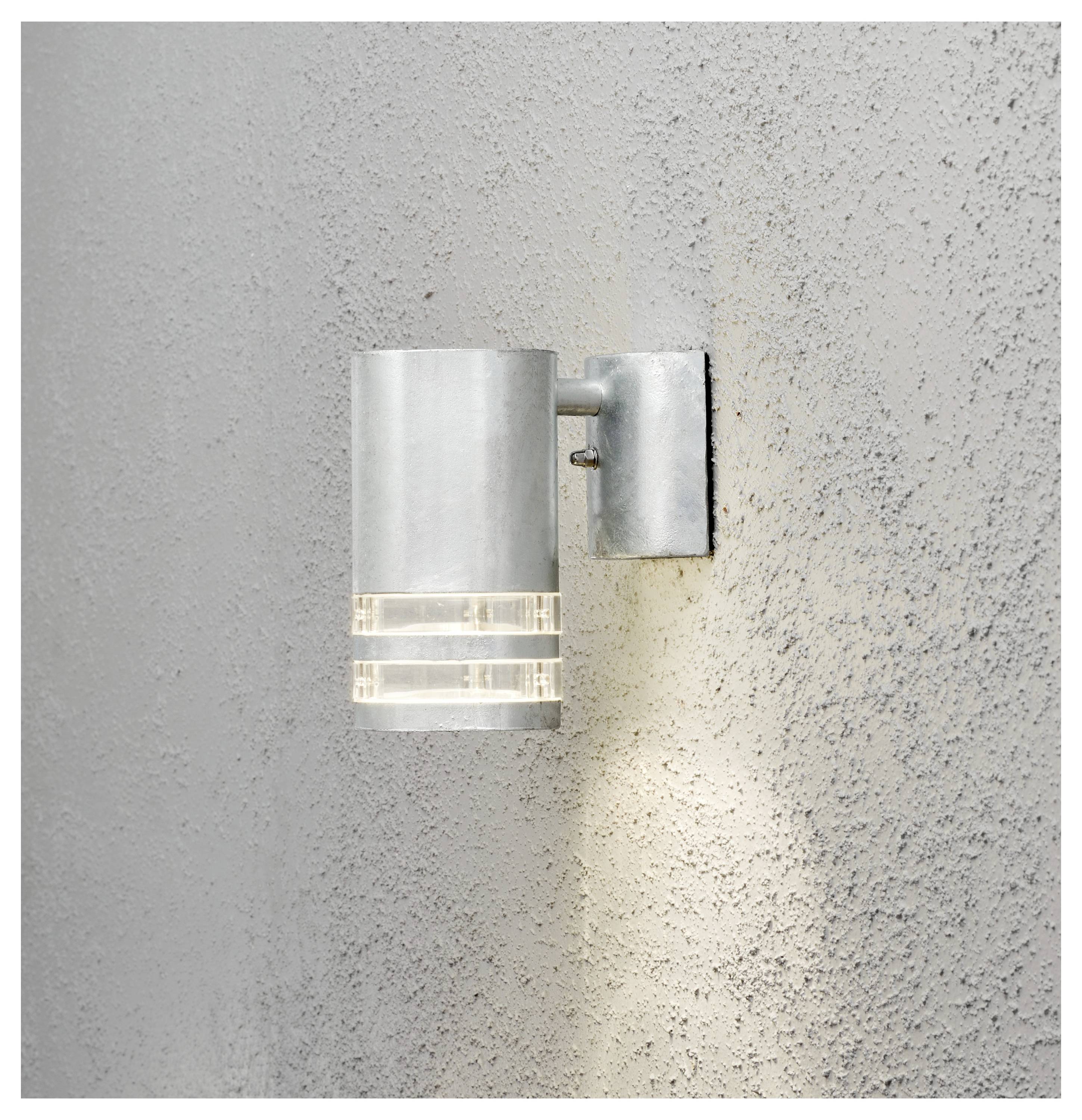 Moderne wandlamp met grijze matglazen kap die een warm omlaag gericht licht op een gestructureerde grijze muur werpt.
