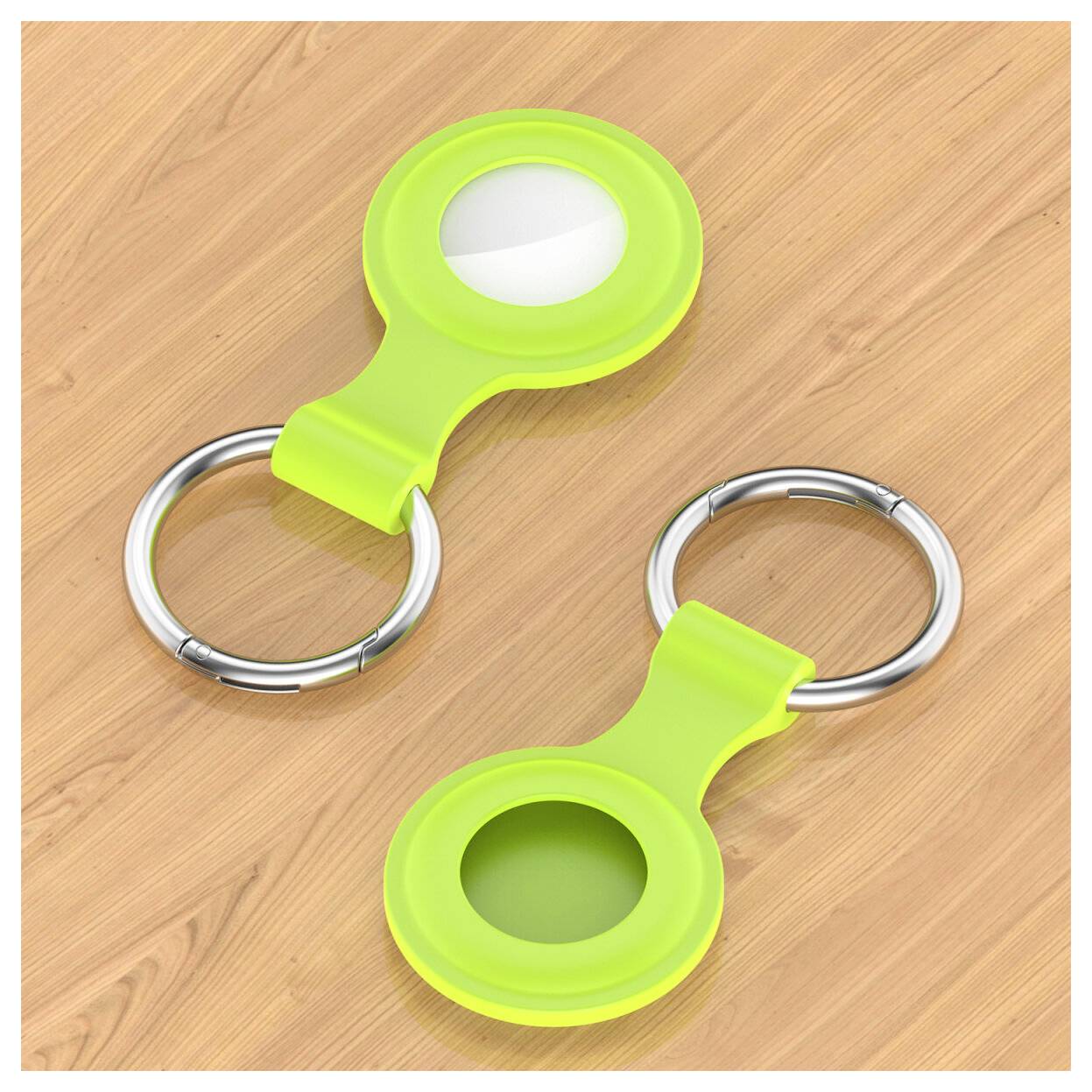 Twee limoengroene sleutelhangers met metalen ringen liggen op een houten oppervlak, één met een wit inzetstuk en de ander met een open circulair middenstuk.