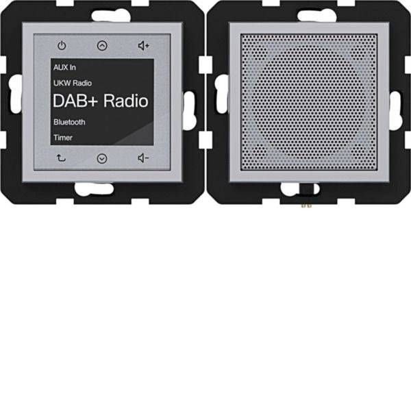 Aan de muur gemonteerd DAB+ radiobedieningspaneel met touchscreen met weergave van AUX In, UKW Radio, Bluetooth en Timer; luidsprekergril ernaast.