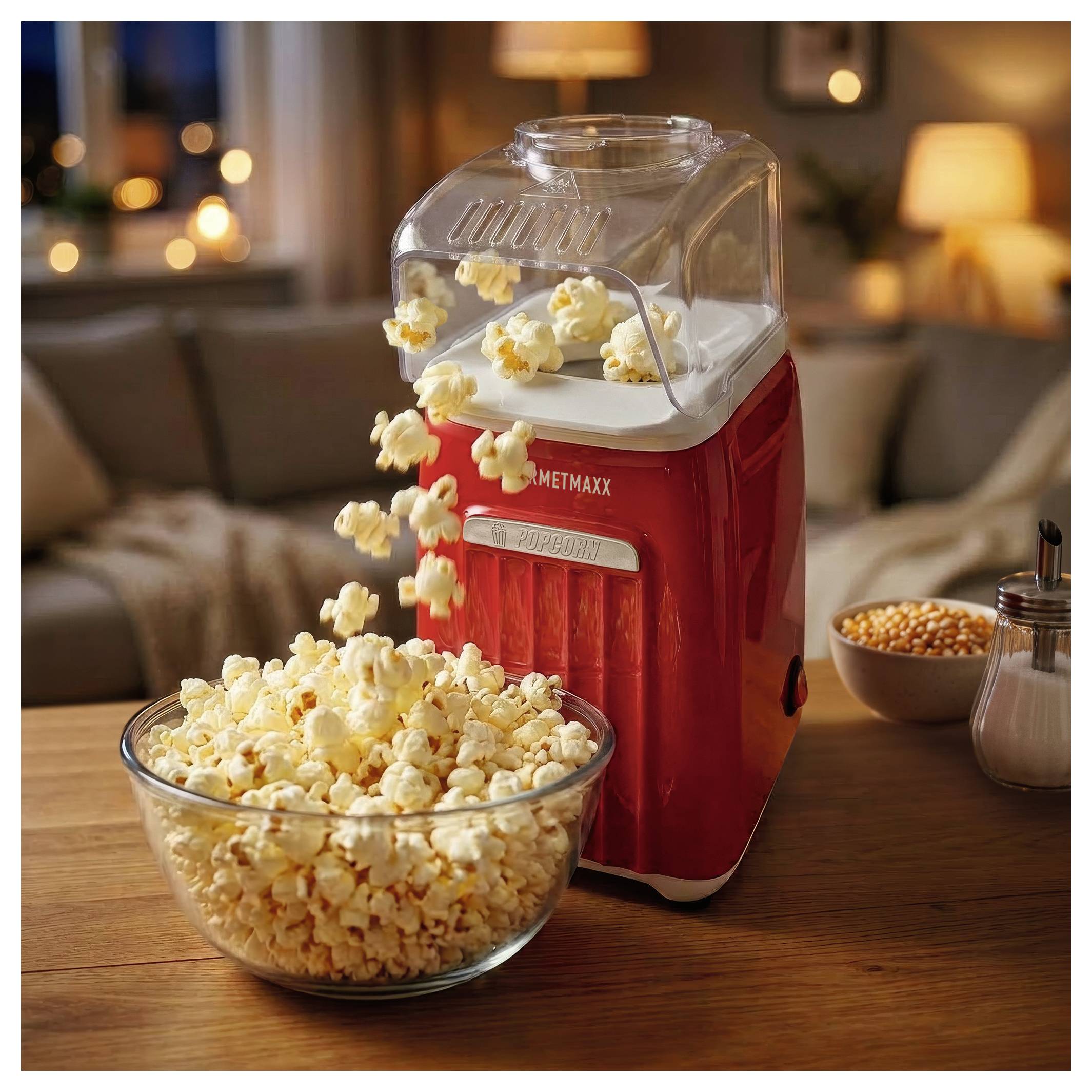 Rode popcornmachine die popcorn in een kom giet op een houten tafel in een gezellige woonkamer.