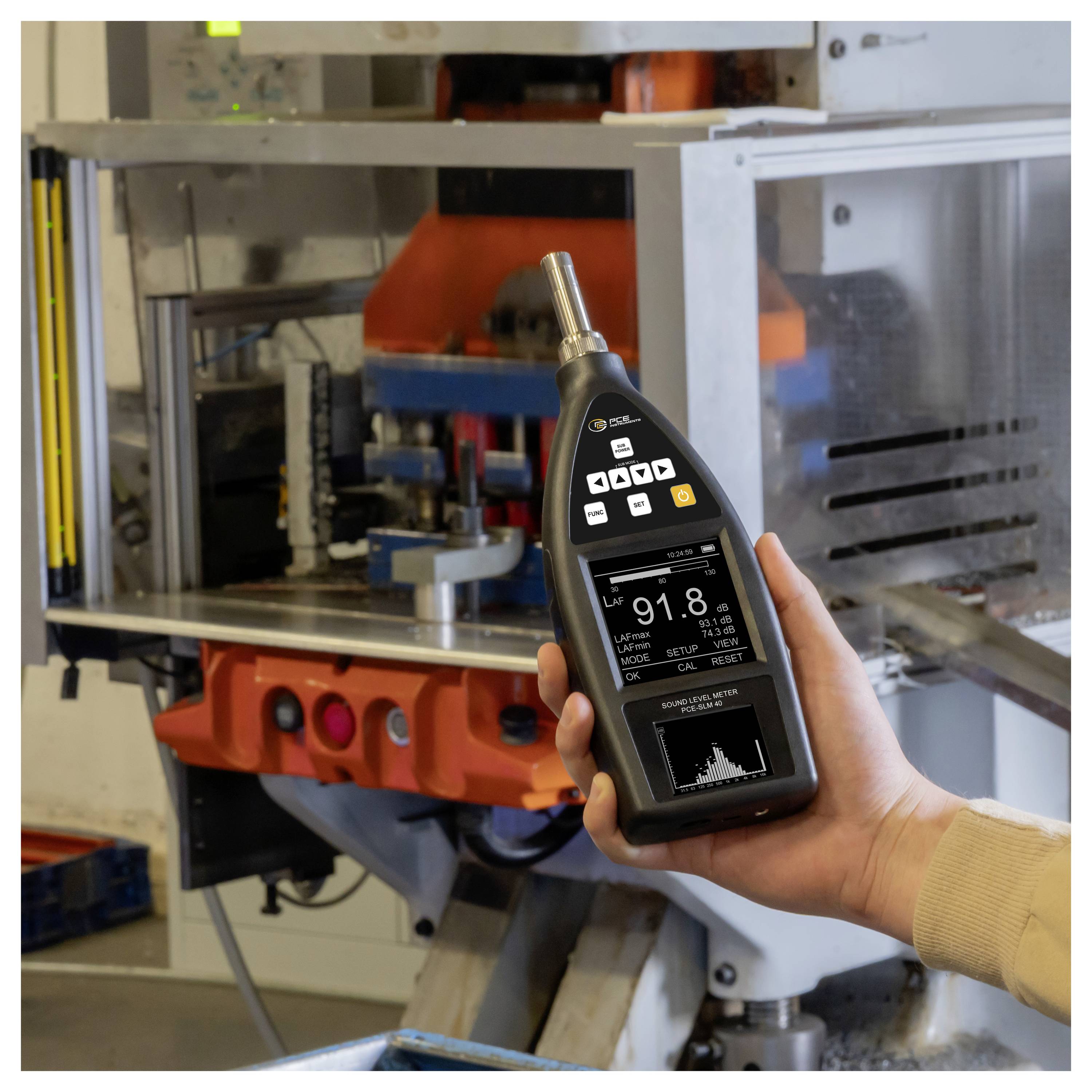 Hand die een handheld meetapparaat vasthoudt voor industriële machines, met aflezingen en een grafiek op het scherm.
