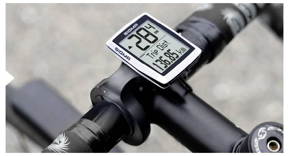 Nahaufnahme van een fietssstuur met een Sigma-fietscomputer die 28°C en een tripafstand van 75,85 km weergeeft.