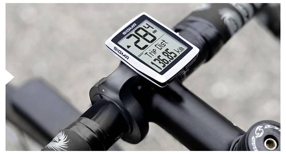Close-up van een fietsstuur met een Sigma-fietscomputer die een temperatuur van 28° toont, Trip Dist 75,65 km en snelheid 0 km/u.