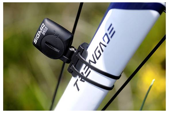Close-up van een fietsbuis met een SIGMA snelheidssensor en kabel gemonteerd op de voorbuis nabij de wielspaken.