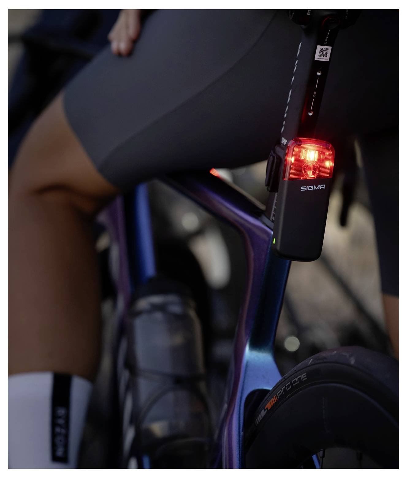 Nahaufnahme van een fiets van een fietser met een helder rood achterveiligheidslicht dat aan het zitbuisje is bevestigd.