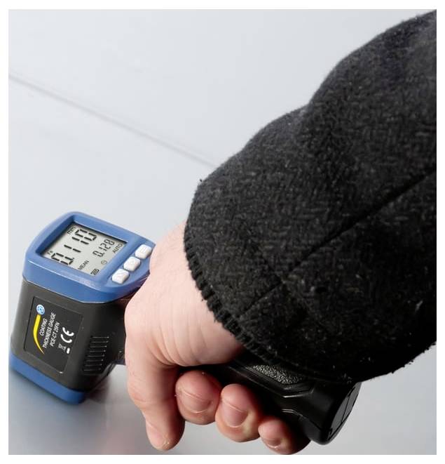 Draagbare digitale infraroodthermometer gericht op een oppervlak, met een temperatuurwaarde op het display.