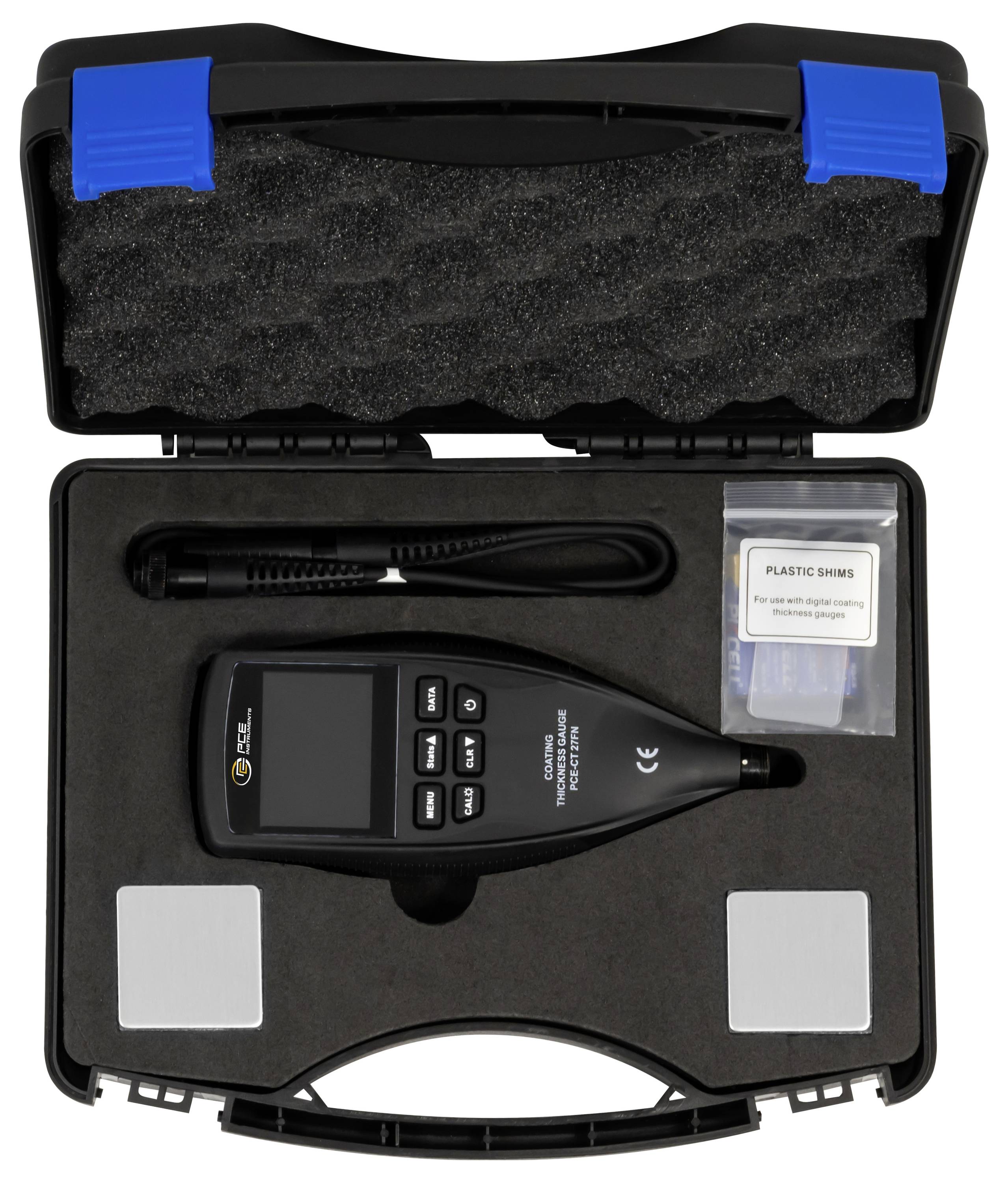 Open kast met een handheld meter, kabel, schuimstof en een zak gelabeld 'PLASTIC SHIMS' voor kalibratie of meetsysteem.