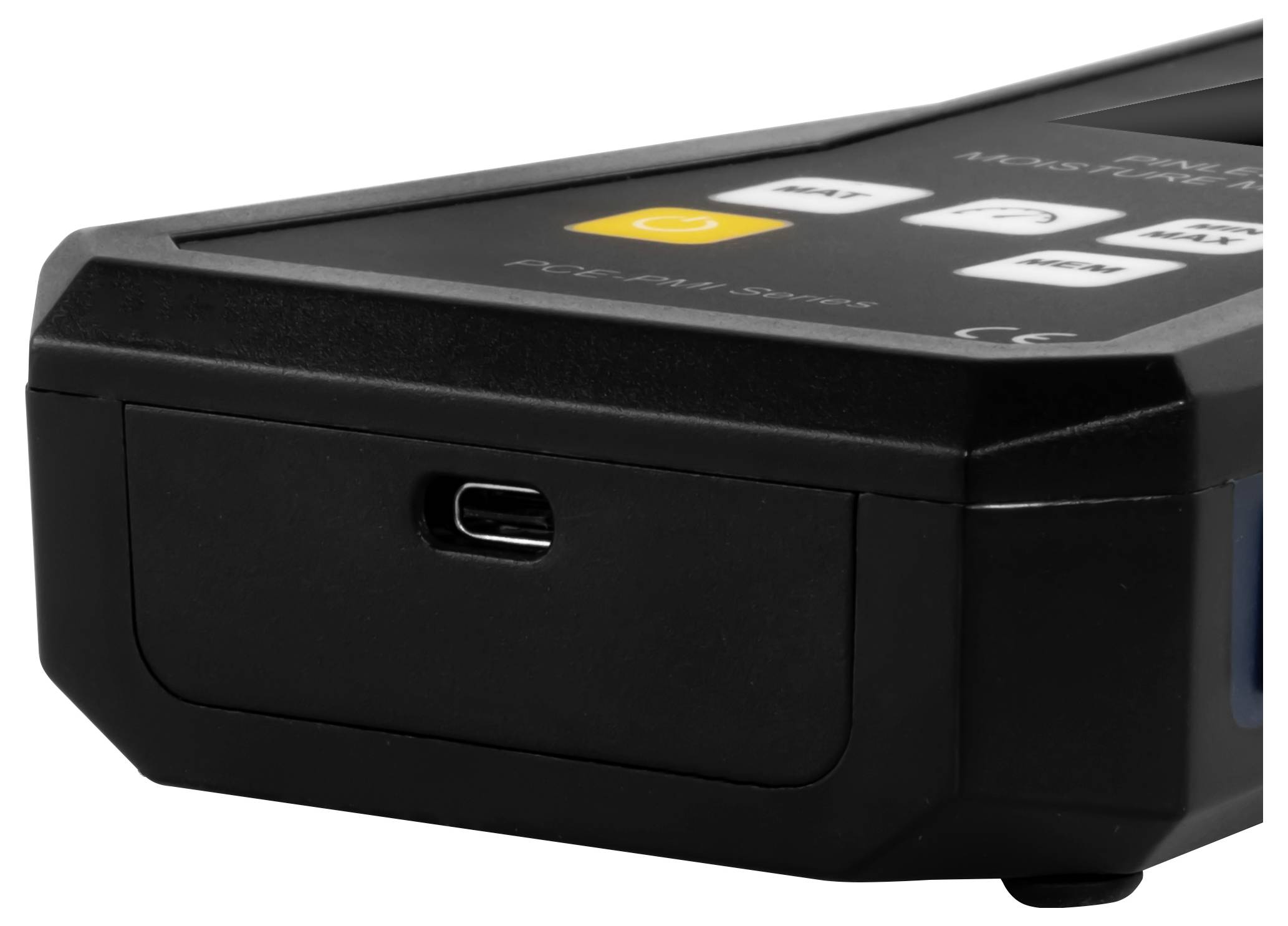 Close-up van een zwart elektronisch apparaat met een voorste USB-C-oplaadpoort en een bovenpaneel met bedieningsknoppen.