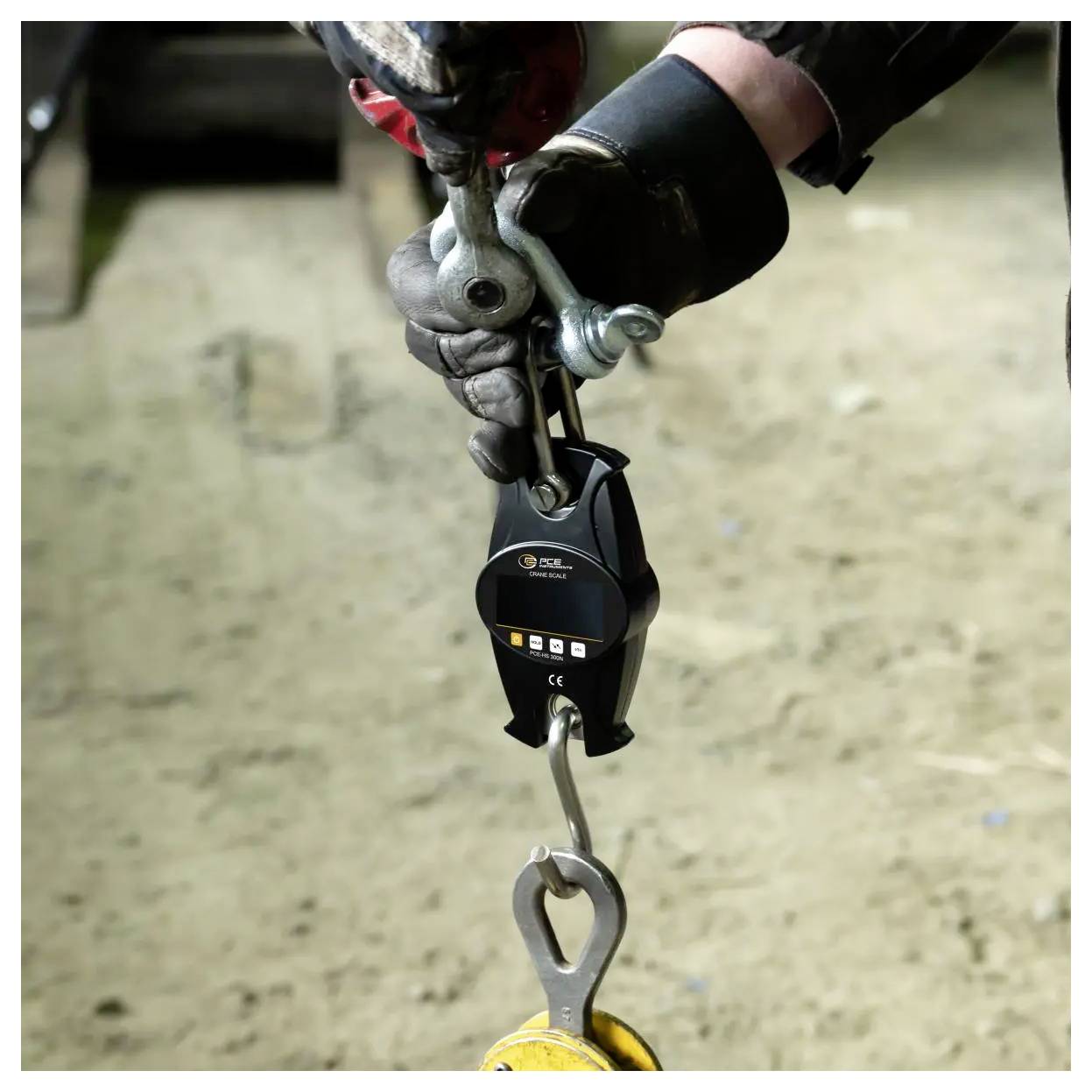 Handschoen dragende werknemer bevestigt een valbeveiliging-lanyardhaak aan een bovenliggende anker met behulp van een metalen karabijner en veiligheidsvoorziening.