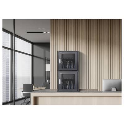 Twee gestapelde aan de muur bevestigde netwerkkasten op een met houtpanelen afgewerkte kantoormuur, naast een bureau en grote ramen in een modern kantoor.