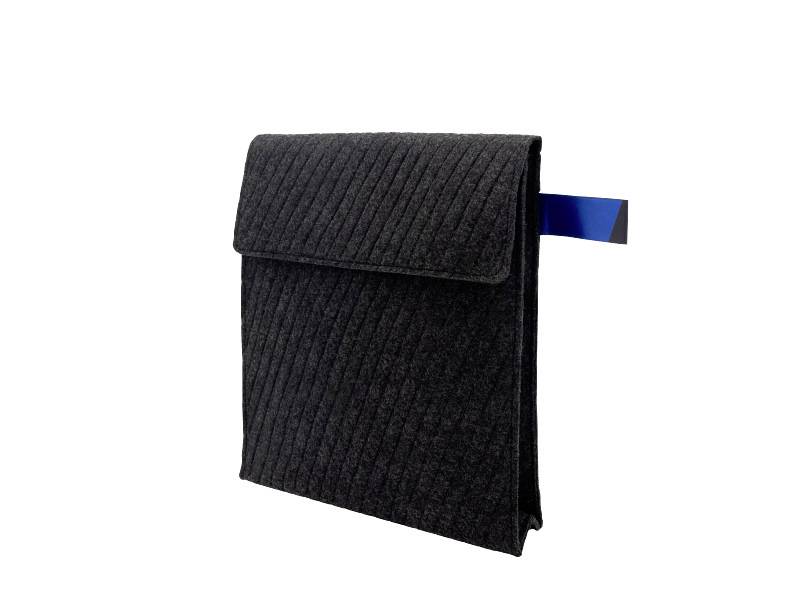 Zwarte geribbelde stoffen zak met een klep en een blauw tabblad, geïsoleerd weergegeven op een witte achtergrond.