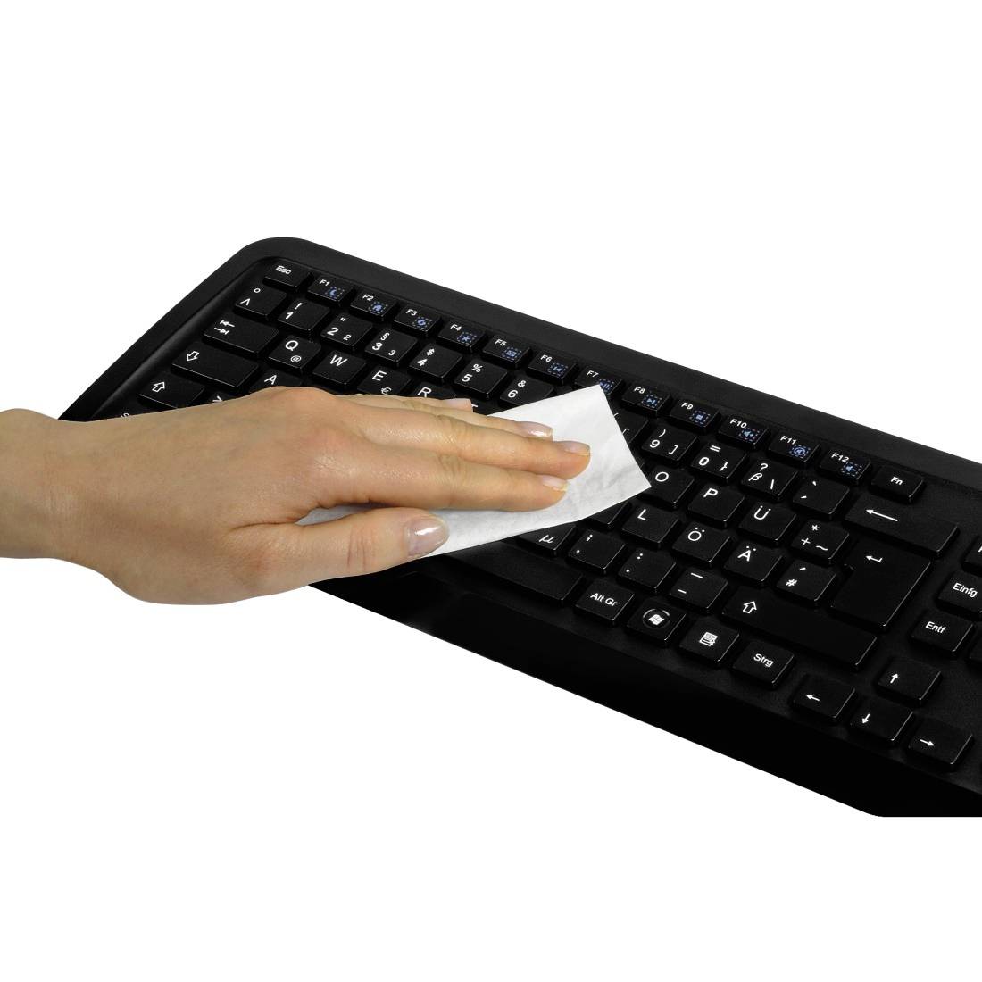 Hand die een zwart computertoetsenbord met een doek op een witte achtergrond afveegt.