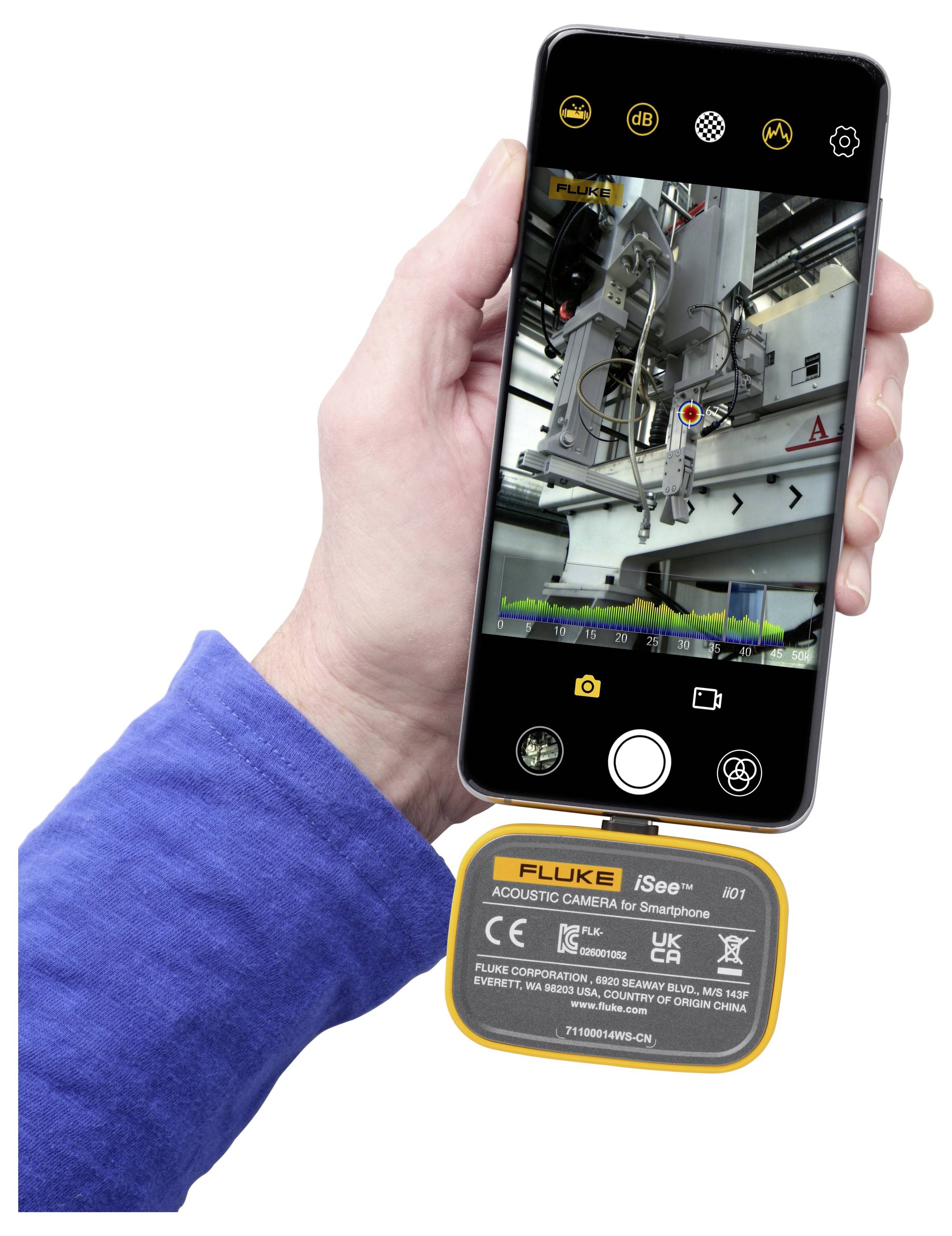 Hand die een smartphone vasthoudt met een daaraan bevestigde Fluke iSee akoestische camera, die een industriële machine op het scherm toont.